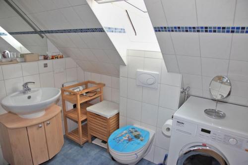 ein Badezimmer mit einem Waschbecken und einer Waschmaschine in der Unterkunft Ferienwohnung Inselblick Norddeich mit Meerblick in Norden