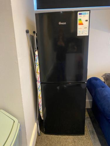 een zwarte koelkast in de hoek van een kamer bij Meadow View in Hurst