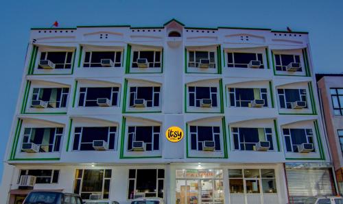 a large white building with a yellow sign on it at Itsy Hotels Satya Shree in Katra