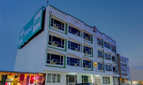 a large white building with chairs in the windows at Itsy Hotels Satya Shree in Katra