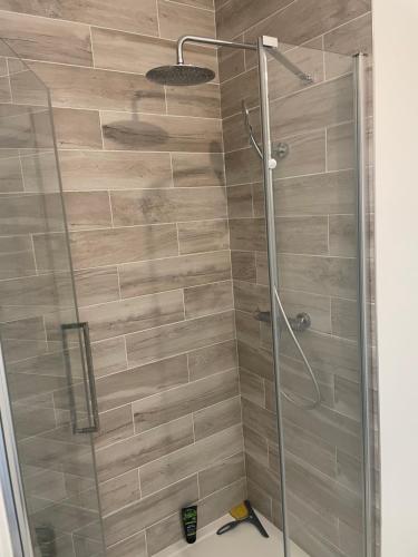 une douche avec une porte vitrée dans une salle de bain dans l'établissement Ndianda, à Bordeaux