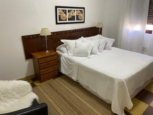 a bedroom with a large bed with white sheets and pillows at “Nelly’s House” Excelente Ubicación y Confort in Carmelo