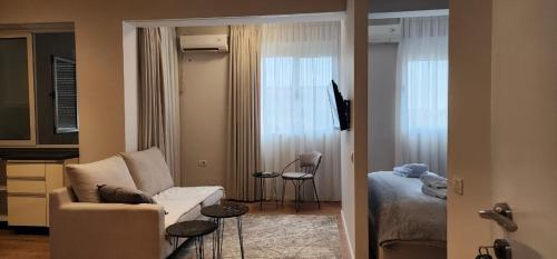 uma sala de estar com um sofá e um quarto em Signature Idea hotel em Tirana