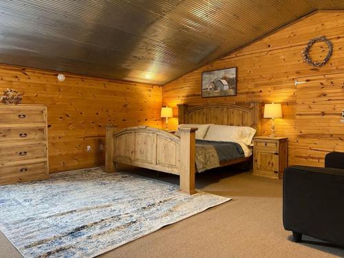 una camera da letto con letto in una camera in legno di Strawberry River Ranch Cabin On 700 Acre Ranch a Horseshoe Bend