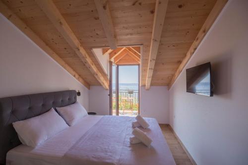 a bedroom with a large bed and a large window at Stone house Marinko - Free Beach Parking in Tučepi