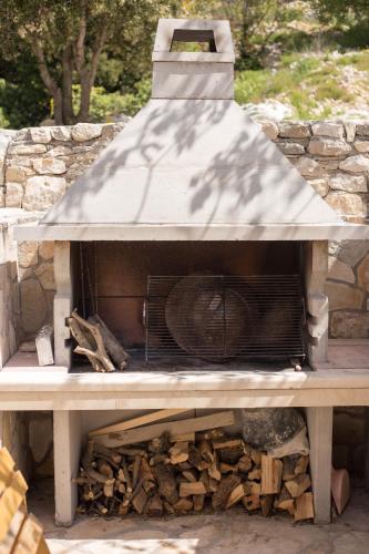 a wood fired oven with a roof on top at Stone house Marinko - Free Beach Parking in Tučepi