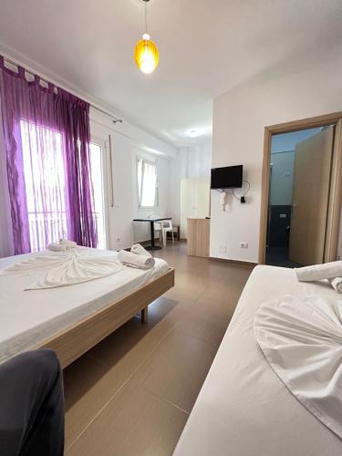 a large room with two beds and a tv at The Blue Horizon in Vlorë