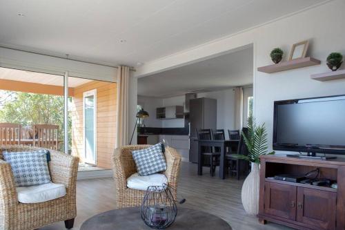 un salon avec une télévision à écran plat et des chaises dans l'établissement Villa Vista Mare 33 Favone 6P superbe vue mer plage Favone 600M, à Conca