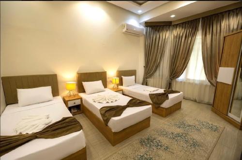 a hotel room with three beds and a window at NEW CITY VIEW in Cairo