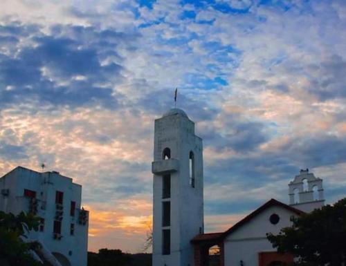 a white building with a cross on top of it at El santorini colombiano en Doradal in Puerto Triunfo