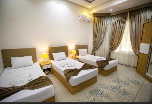 a room with three beds and two lamps and a window at NEW CITY VIEW in Cairo