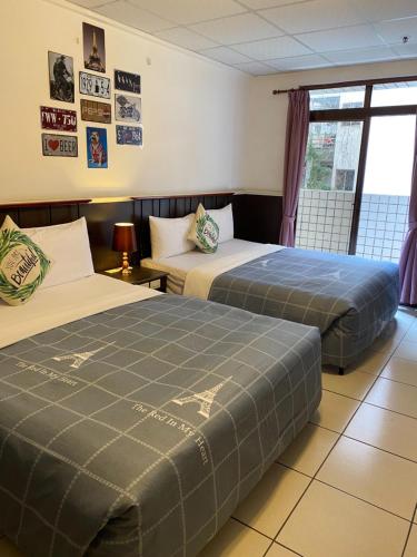 a hotel room with two beds and a window at Zhiben Hotspring in Wenquan