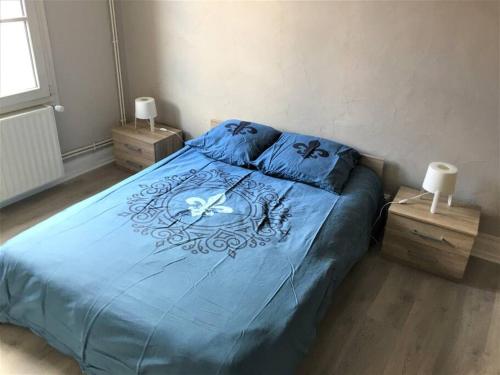 a bedroom with a blue bed with two night stands at Appartement 3 pièces pleins de charmes (Virginie) in Montbéliard