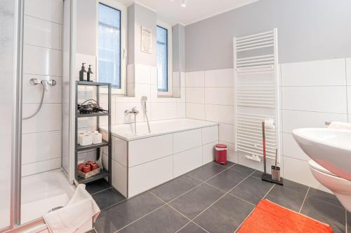 een badkamer met een wastafel, een bad en een toilet bij Golden Design Zentral Office Kitchen Garage in Duisburg