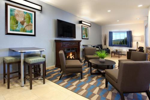 a living room with a fireplace and a tv at Microtel Inn & Suites by Wyndham Waynesburg in Waynesburg