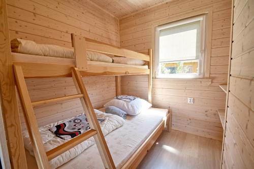 a bedroom with bunk beds in a wooden cabin at Rumiankowa Polana in Sarbinowo