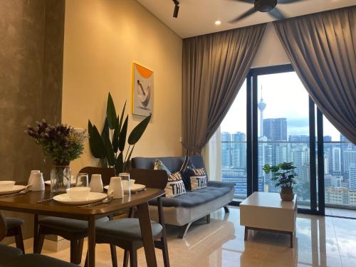 Harmony Luxury Suites At Lucentia Bukit Bintang City Center في كوالالمبور: غرفة معيشة مع طاولة طعام وأريكة