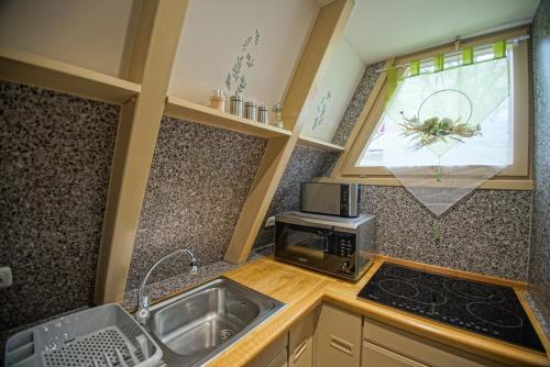 a small kitchen with a sink and a microwave at Ferienhaus Nordic Harmony in Waldkirchen