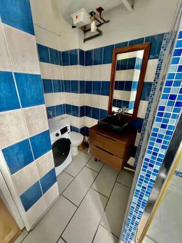 une salle de bain avec toilettes, lavabo et miroir dans l'établissement L évasion, à Amiens