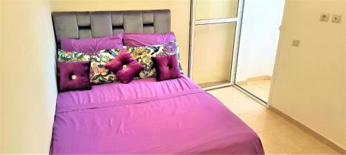a bed with pink sheets and pillows on it at joli appartement près de la mer in Casablanca