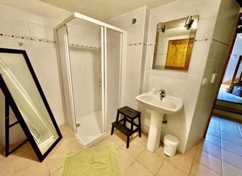 a white bathroom with a shower and a sink at La Colline du Chat Perche in Connac