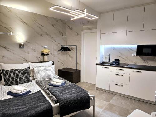 a living room with a couch and a kitchen at Studio Carmen in Piran