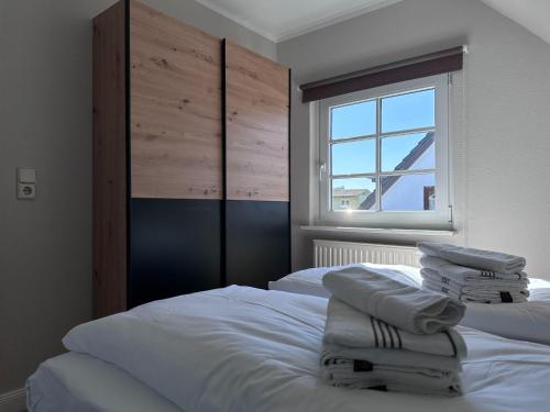 ヴェスターラントにあるSchmucke-Huus-Appartement-3のベッドルーム1室(ベッド2台、タオル付)