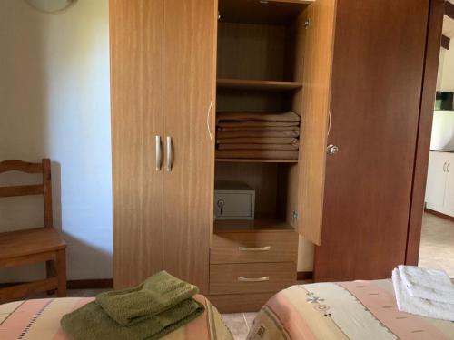 a bedroom with a wooden cabinet with towels in it at Casa Picaflor UY in Jaureguiberry