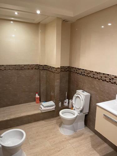 a bathroom with a toilet and a sink and a tub at Cosy appartement in Casablanca