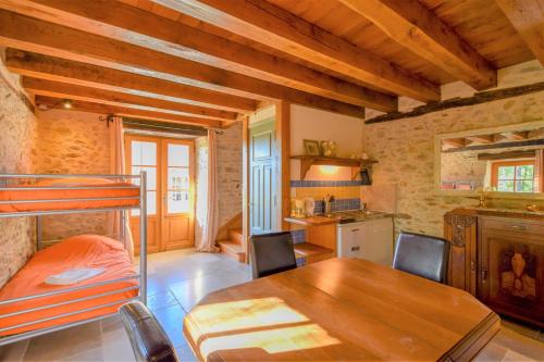 a bedroom with a bunk bed and a table in a room at Domaine d'Essendiéras in Saint-Médard-dʼExcideuil