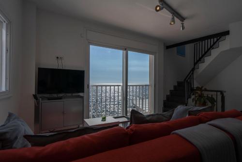 uma sala de estar com um sofá e uma grande janela em Beachhouse with amazing terrace next to the ocean em Bocacangrejo