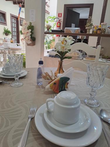 a table with a white cup and plate on it at La Coloniale in Búzios