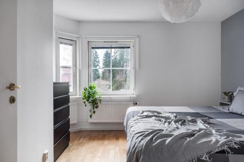 a white bedroom with a bed and a window at Uppsala Large family home beside forest in Uppsala