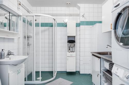 a bathroom with a sink and a washing machine at Uppsala Large family home beside forest in Uppsala