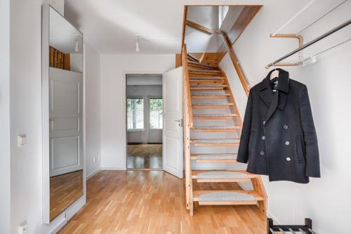 a staircase in a house with a coat hanging on it at Uppsala Large family home beside forest in Uppsala