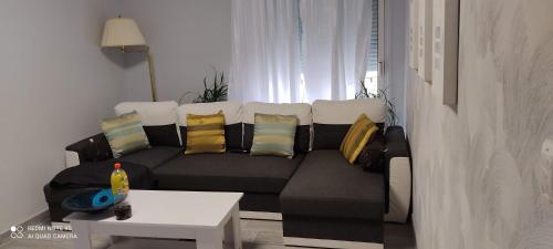 ein Wohnzimmer mit einem schwarzen Sofa und bunten Kissen in der Unterkunft Cannes carnot in Cannes