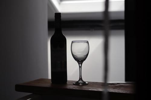 una botella de vino y una copa de vino en una mesa en Berry's Loft - Central Location and Fast WIFI, en Knaresborough