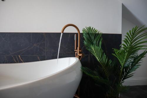 baño con bañera y planta en Berry's Loft - Central Location and Fast WIFI, en Knaresborough