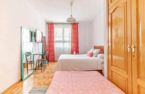1 dormitorio con 2 camas y mesa. en Acogedora Habitación en Madrid, en Madrid