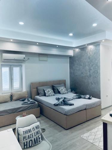 a bedroom with two beds and a chair in it at Apartman Katarina in Trebinje