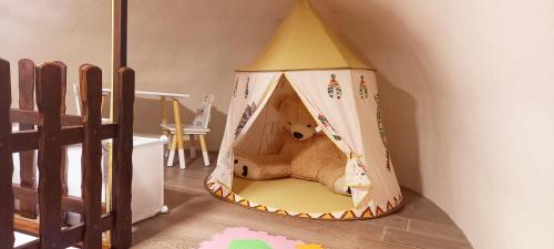 a teddy bear inside a teepee tent in a room at Krka Fairytale village in Rupe