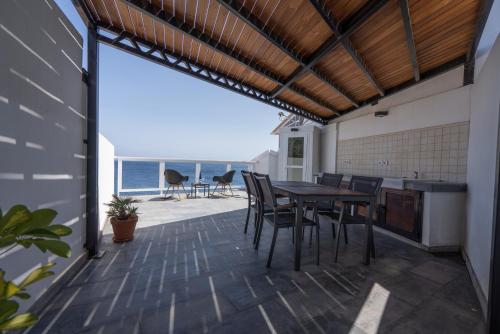 um pátio com uma mesa e cadeiras e o oceano em Beachhouse with amazing terrace next to the ocean em Bocacangrejo