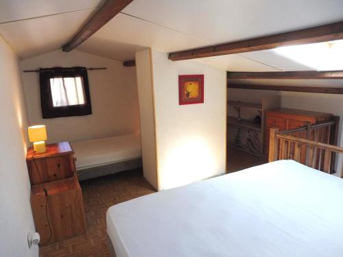 une chambre avec un lit blanc et une fenêtre dans l'établissement ALOA Joli 2 Pièces avec mezzanine piscine proche plage Richelieu Cap d'Agde, au Cap d'Agde