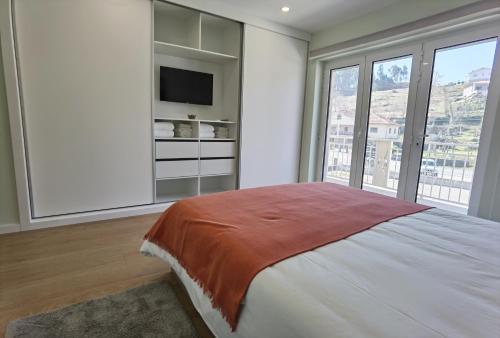 a bedroom with a large bed and a tv at Encanto de Arcos de Valdevez 2 in Arcos de Valdevez