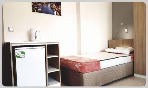 a small bedroom with a bed and a small table at Akademi Suit in Eskisehir