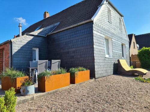 une maison noire avec une aire de jeux et un toboggan dans l'établissement Schiefer Huus, à Krummhörn