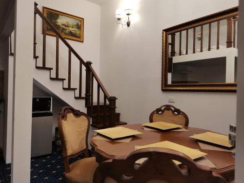 ein Esszimmer mit einem Tisch und einem Spiegel in der Unterkunft Weiss Little Palace in Braşov