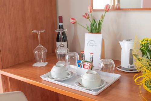 a table with two tea cups and glasses on it at Porta delle Botteghelle in Trapani