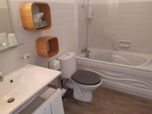 La salle de bains est pourvue de toilettes, d'un lavabo et d'une baignoire. dans l'établissement Hôtel Ker-Noyal Quiberon Plage, à Quiberon