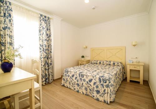 a small bedroom with a bed and a window at Apartamentos Turísticos Gran Sol in Zahara de los Atunes